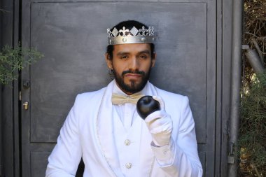 Kral tacıyla karnaval kostümlü yakışıklı genç adamın yakın plan portresi.