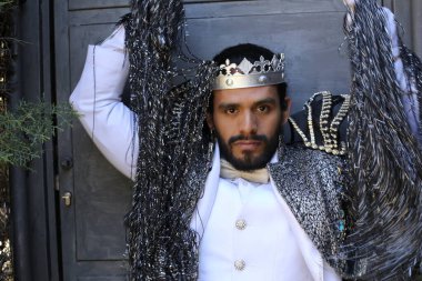 Kral tacıyla karnaval kostümlü yakışıklı genç adamın yakın plan portresi.