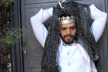 Kral tacıyla karnaval kostümlü yakışıklı genç adamın yakın plan portresi.