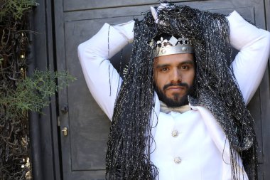 Kral tacıyla karnaval kostümlü yakışıklı genç adamın yakın plan portresi.