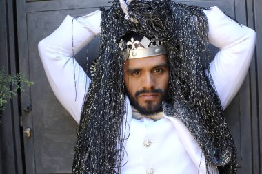 Kral tacıyla karnaval kostümlü yakışıklı genç adamın yakın plan portresi.