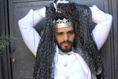 Kral tacıyla karnaval kostümlü yakışıklı genç adamın yakın plan portresi.