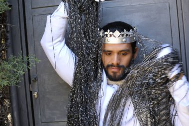 Kral tacıyla karnaval kostümlü yakışıklı genç adamın yakın plan portresi.