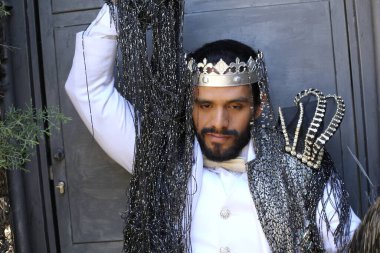 Kral tacıyla karnaval kostümlü yakışıklı genç adamın yakın plan portresi.