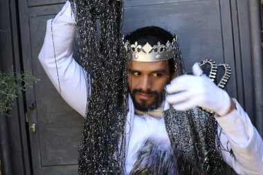 Kral tacıyla karnaval kostümlü yakışıklı genç adamın yakın plan portresi.