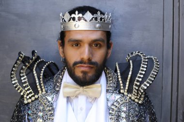 Kral tacıyla karnaval kostümlü yakışıklı genç adamın yakın plan portresi.