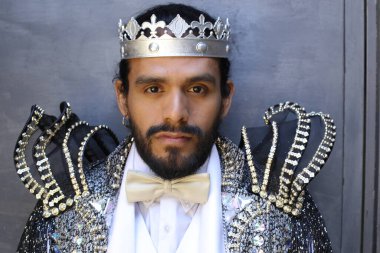 Kral tacıyla karnaval kostümlü yakışıklı genç adamın yakın plan portresi.