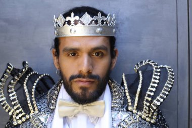 Kral tacıyla karnaval kostümlü yakışıklı genç adamın yakın plan portresi.