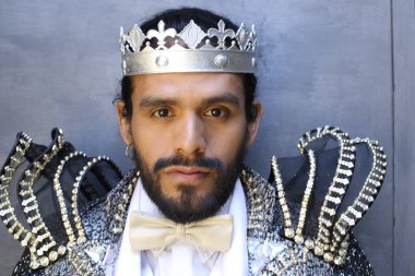 Kral tacıyla karnaval kostümlü yakışıklı genç adamın yakın plan portresi.