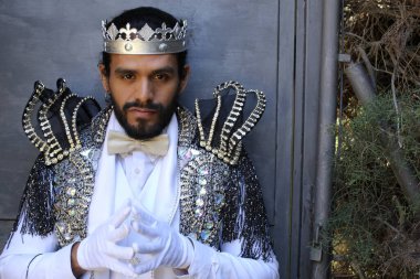 Kral tacıyla karnaval kostümlü yakışıklı genç adamın yakın plan portresi.