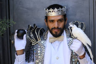 Kral tacıyla karnaval kostümlü yakışıklı genç adamın yakın plan portresi.