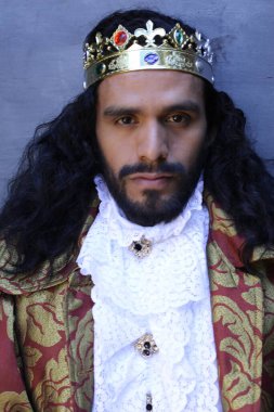 Kral tacıyla karnaval kostümlü yakışıklı genç adamın yakın plan portresi.