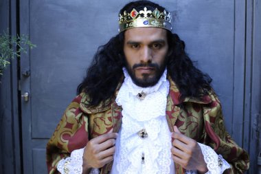 Kral tacıyla karnaval kostümlü yakışıklı genç adamın yakın plan portresi.