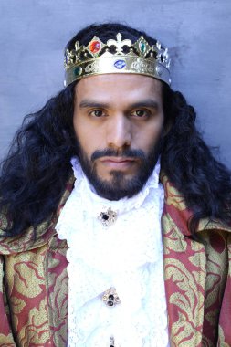 Kral tacıyla karnaval kostümlü yakışıklı genç adamın yakın plan portresi.