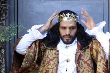 Kral tacıyla karnaval kostümlü yakışıklı genç adamın yakın plan portresi.