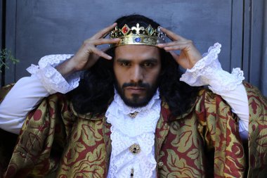 Kral tacıyla karnaval kostümlü yakışıklı genç adamın yakın plan portresi.