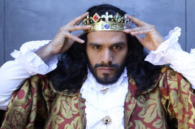 Kral tacıyla karnaval kostümlü yakışıklı genç adamın yakın plan portresi.