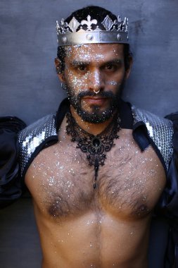 Kral tacıyla karnaval kostümlü yakışıklı genç adamın yakın plan portresi.