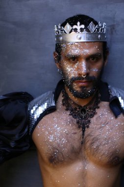 Kral tacıyla karnaval kostümlü yakışıklı genç adamın yakın plan portresi.