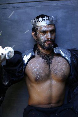 Kral tacı ve ayna topuyla şık bir karnaval kostümü giymiş yakışıklı genç adamın yakın plan portresi.