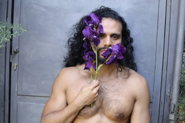 年轻英俊无袖男子的特写 手持紫色兰花 — 图库照片