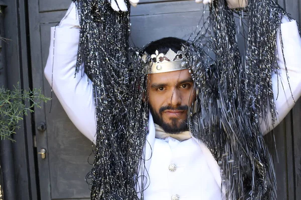 Kral tacıyla karnaval kostümlü yakışıklı genç adamın yakın plan portresi.