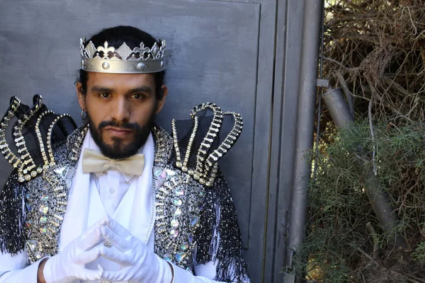 Kral tacıyla karnaval kostümlü yakışıklı genç adamın yakın plan portresi.