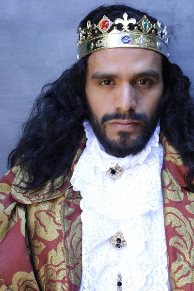 Kral tacıyla karnaval kostümlü yakışıklı genç adamın yakın plan portresi.