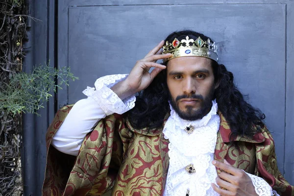 Kral tacıyla karnaval kostümlü yakışıklı genç adamın yakın plan portresi.