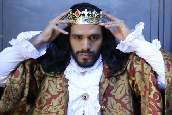 Kral tacıyla karnaval kostümlü yakışıklı genç adamın yakın plan portresi.