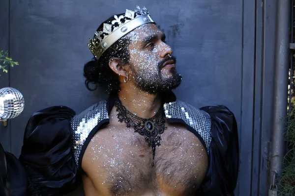 Kral tacı ve ayna topuyla şık bir karnaval kostümü giymiş yakışıklı genç adamın yakın plan portresi.