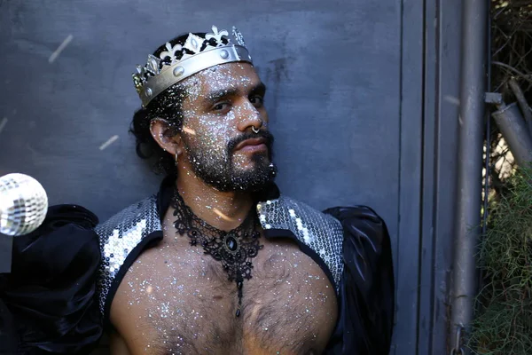 Kral tacı ve ayna topuyla şık bir karnaval kostümü giymiş yakışıklı genç adamın yakın plan portresi.