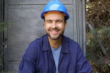 Üniformalı ve miğferli genç bir işçinin yakın plan portresi.