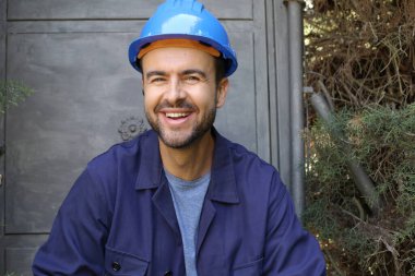 Üniformalı ve miğferli genç bir işçinin yakın plan portresi.