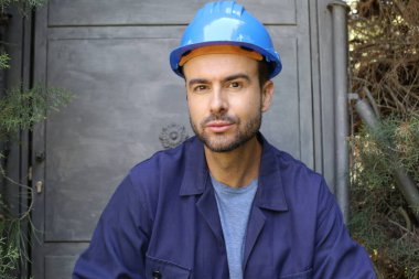 Üniformalı ve miğferli genç bir işçinin yakın plan portresi.