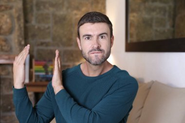 Evde el kol hareketi yapan yakışıklı genç adamın yakın plan portresi.