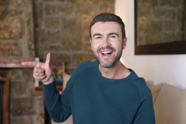 Evde el kol hareketi yapan yakışıklı genç adamın yakın plan portresi.