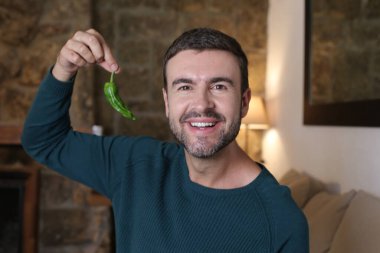 Evde yeşil biberli yakışıklı bir gencin yakın plan portresi.