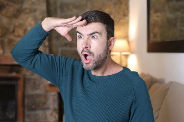 Evde el kol hareketi yapan yakışıklı genç adamın yakın plan portresi.