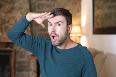 Evde el kol hareketi yapan yakışıklı genç adamın yakın plan portresi.