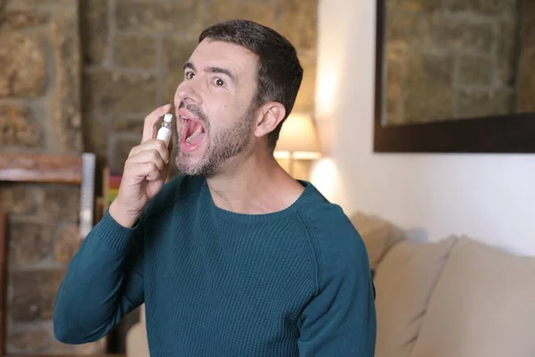 Close Portrait Handsome Young Man Spraying Mint His Mouth Home — Stockfoto