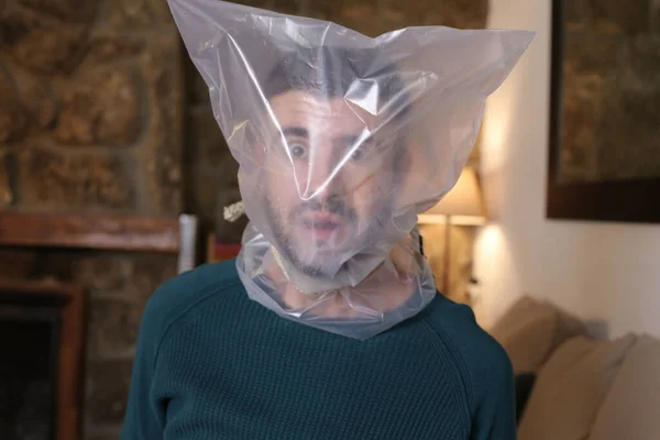 Close Portrait Scared Young Man Plastic Bag Head Home — Stockfoto