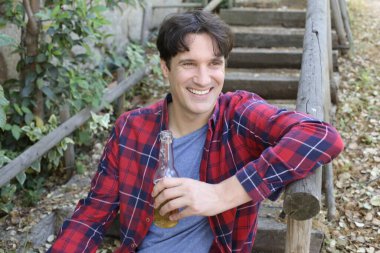 Elinde bira şişesi olan yakışıklı bir gencin portresi.