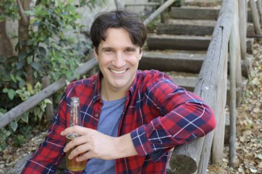 Elinde bira şişesi olan yakışıklı bir gencin portresi.