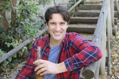 Elinde bira şişesi olan yakışıklı bir gencin portresi.