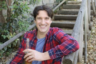 Elinde bira şişesi olan yakışıklı bir gencin portresi.