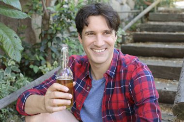 Elinde bira şişesi olan yakışıklı bir gencin portresi.