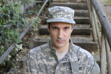 Dışarıdaki üniformalı yakışıklı genç askerin portresi.