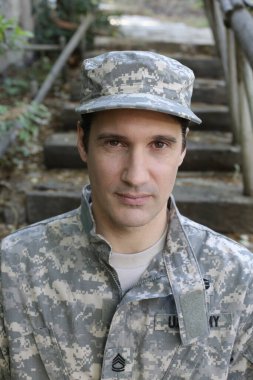 Dışarıdaki üniformalı yakışıklı genç askerin portresi.