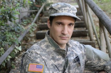 Dışarıdaki üniformalı yakışıklı genç askerin portresi.